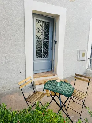 two chairs and a table in front of a door at L'Échappée Belle Studio in Châteaurenard