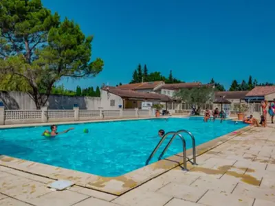 a large swimming pool with people in the water at Chalet 46m² avec Terrasse à Noves - API-1-52-531 in Noves