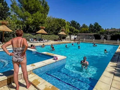 a woman in a bathing suit standing in a swimming pool at Chalet confort avec terrasse - 5 personnes - API-1-52-621 in Noves
