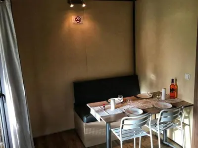 a dining room table with chairs and a table and ahibited at Chalet confort avec terrasse - 5 personnes - API-1-52-621 in Noves