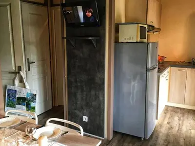 a kitchen with a refrigerator with a tv on top at Chalet confort avec terrasse - 5 personnes - API-1-52-621 in Noves