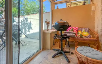 a grill on a stand in a room with a window at Proche Alpilles in Eyragues