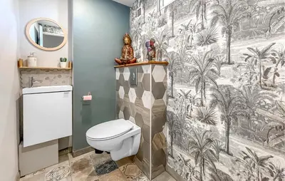 a bathroom with a toilet and a wallpaper with palm trees at Proche Alpilles in Eyragues