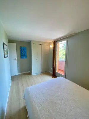 a bedroom with a large bed and a large window at Le Pré de la Reyne in Sault-de-Vaucluse