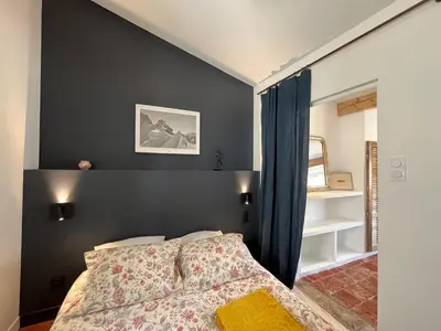 a bedroom with a bed and a black wall at Appartement cocooning centre ville in Aix-en-Provence