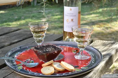 a plate with a bottle of wine and two glasses at Les Chambres du Luberon & Table d'hôtes in Lauris