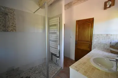 a bathroom with a sink and a glass shower at Les Chambres du Luberon & Table d'hôtes in Lauris