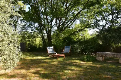 two chairs sitting in the shade of a tree at Les Chambres du Luberon & Table d'hôtes in Lauris