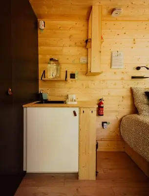 a small kitchen with wooden walls and a counter at Homnest - Infusion Provençale - Lisière & Ocres in Viens