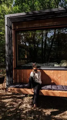 a woman sitting on a bench in a shed at Homnest - Infusion Provençale - Lisière & Ocres in Viens