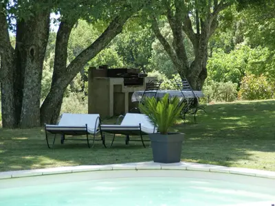 a pool with two chairs and a grill and trees at Villa in Reillanne with Private Pool in Reillanne