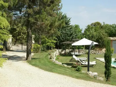a yard with chairs and an umbrella and a pool at Villa in Reillanne with Private Pool in Reillanne
