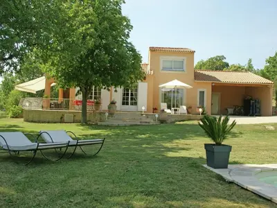 a house with two lawn chairs in the yard at Villa in Reillanne with Private Pool in Reillanne