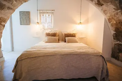 a bedroom with a large bed with two pillows at Évasion grecque en duo Suite balnéo Wifi in Carpentras