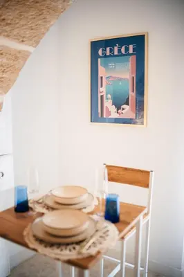 a dining room table with plates on top of it at Évasion grecque en duo Suite balnéo Wifi in Carpentras