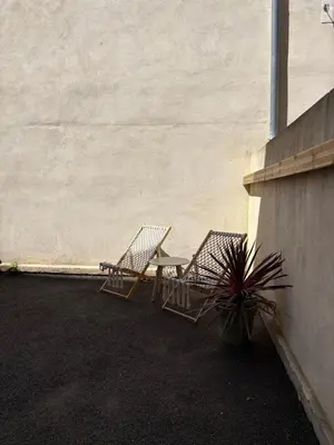 two chairs sitting on a patio next to a wall at Évasion grecque en duo Suite balnéo Wifi in Carpentras