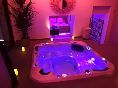 a hot tub in a room with purple lighting at Cocon D'amour En Luberon - Chambre Spa a proximite de l'Isle sur la Sorgue in LʼIsle-sur-la-Sorgue