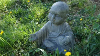 a statue of a child sitting in the grass at Cocon D'amour En Luberon - Chambre Spa a proximite de l'Isle sur la Sorgue in LʼIsle-sur-la-Sorgue