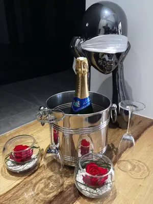 a bottle of champagne in a ice bucket and roses at Cocon D'amour En Luberon - Chambre Spa a proximite de l'Isle sur la Sorgue in LʼIsle-sur-la-Sorgue