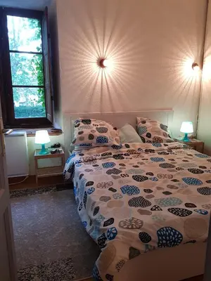 a bedroom with a bed and two lamps and a window at Au pied du Colorado Provencal in Rustrel