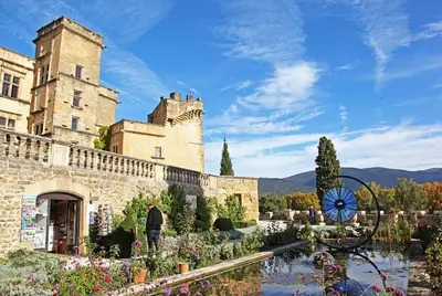a man is standing in front of a castle at Au pied du Colorado Provencal in Rustrel
