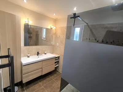a bathroom with a sink and a large mirror at La Colline sous les etoiles in Lincel