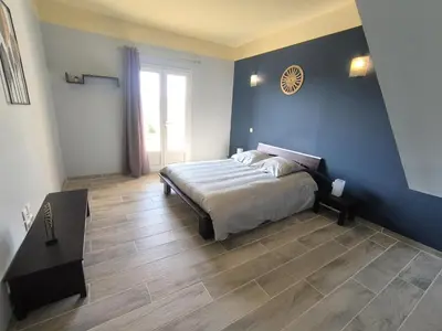 a bedroom with a bed and a blue wall at La Colline sous les etoiles in Lincel