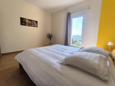 a bedroom with a large bed with a large window at La Colline sous les etoiles in Lincel