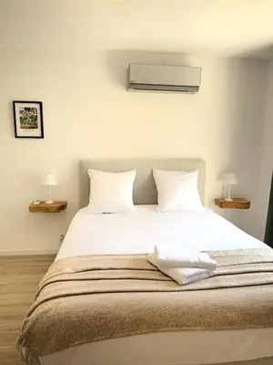 a bedroom with a large bed with white sheets and pillows at Villa des Glauges in Eyguières