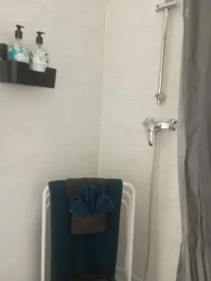 a bathroom with a shower with a blue towel on a chair at Evasion Aixoise logement T2 au Centre historique in Aix-en-Provence