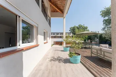 a balcony with two potted plants on a house at Villa le Trèfle with pool in Velaux