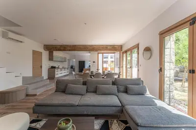 a living room with a large couch and a kitchen at Villa le Trèfle with pool in Velaux