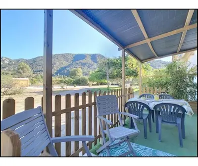 a porch with blue chairs and a table with a view at Mon paradis in Maubec