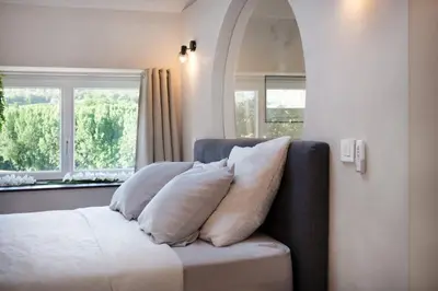 a couch with pillows on it in a room with windows at Domaine Paradis in Reillanne