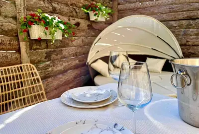 a table with two wine glasses and plates on it at Domaine Paradis in Reillanne