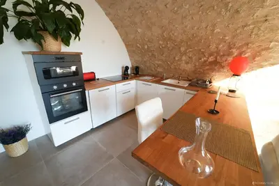 a kitchen with a wooden table and an oven at Domaine Paradis in Reillanne