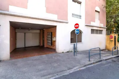 a building with a garage and a sign in front of it at Charmant appart central avec Terrasse & Clim in Aix-en-Provence