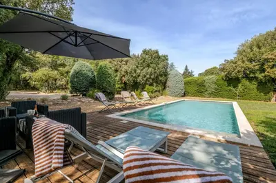 a swimming pool with chairs and an umbrella at La Mathilde - Premium Pool Villa Private Tree-Top Adventure in Bonnieux