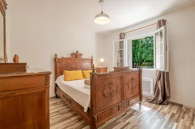 a bedroom with a wooden bed and a window at La Mathilde - Premium Pool Villa Private Tree-Top Adventure in Bonnieux