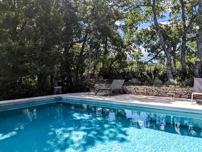 a pool with a chair and a laptop on a patio at Contemporary Villa With Pool In Céreste-En-Luberon in Céreste