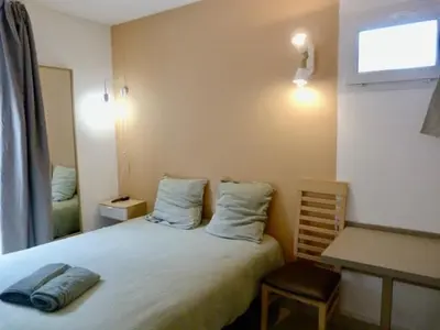 a bedroom with a bed and a desk and a window at Le Clos d'AIX Studio 113 in Aix-en-Provence