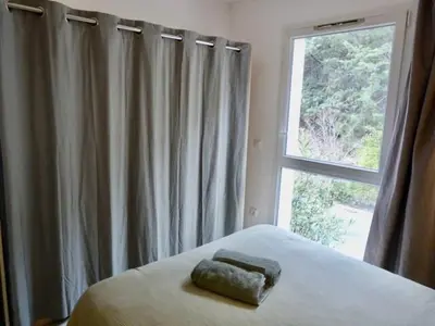 a bed with a towel on it in front of a window at Le Clos d'AIX Studio 113 in Aix-en-Provence