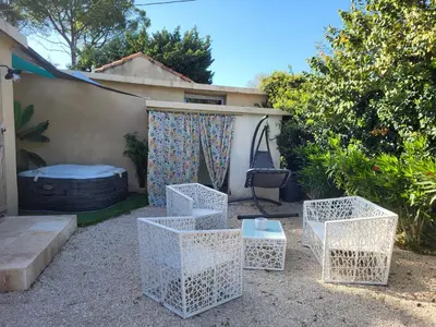 a group of white nesting tables in a yard at Maison BRIALI avec Jacuzzi espace détente in Aubignan