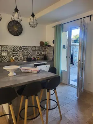 a kitchen with a table and chairs in a room at Maison BRIALI avec Jacuzzi espace détente in Aubignan