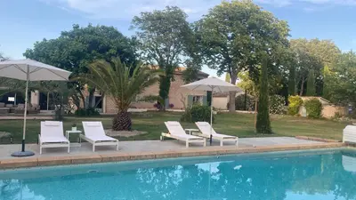 a group of chairs and umbrellas next to a pool at Mas de la Calade Bed & Breakfast in Aix-en-Provence