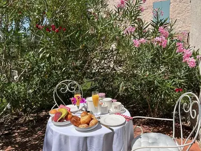 a table with a white table cloth with food on it at Mas de la Calade Bed & Breakfast in Aix-en-Provence