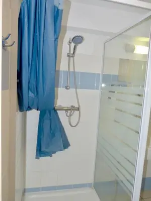 a shower with a blue shower curtain in a bathroom at Le Clos d'AIX Studio 304 Parking in Aix-en-Provence