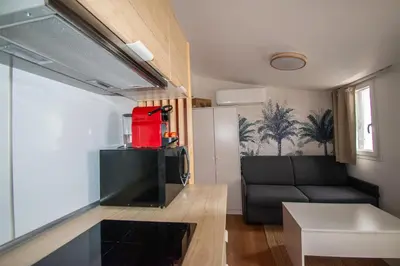 a small kitchen and living room with a couch at Studio climatisé avec terrasse, 5ème étage sans ascenseur in Aix-en-Provence