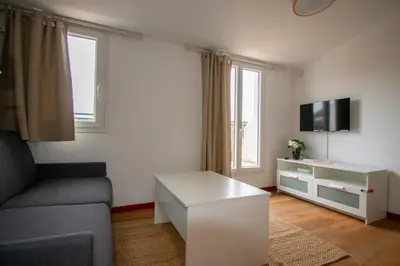 a living room with a couch and a tv at Studio climatisé avec terrasse, 5ème étage sans ascenseur in Aix-en-Provence