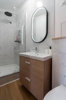 a bathroom with a sink and a shower with a mirror at Studio climatisé avec terrasse, 5ème étage sans ascenseur in Aix-en-Provence